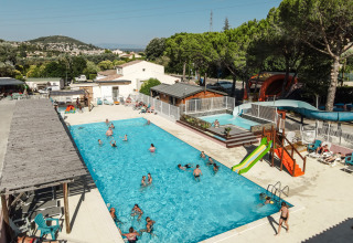 Buitenzwembad met glijbaan en ligstoelen bij Flower Camping Provence Vallée in Provence-Alpes-Côte d’Azur, Frankrijk.