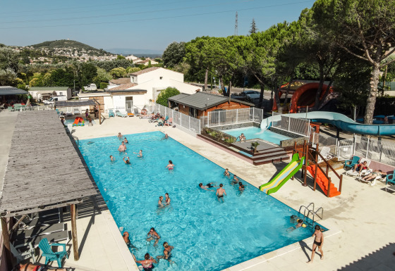Piscine extérieure avec toboggan et chaises longues au Flower Camping Provence Vallée, Provence-Alpes-Côte d’Azur.