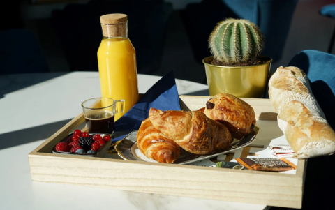 Vassoio per la colazione con croissant, succo, caffè, frutti di bosco e baguette a Family's Camping Le Savoy.