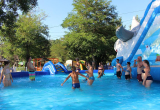 Familien entspannen sich im Pool mit Wasserrutsche im Camping Paradis Family des Issoux, Auvergne-Rhône-Alpes.