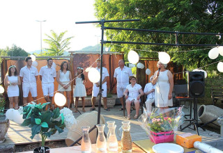 Celebración al aire libre en Camping Paradis Family des Issoux en Auvergne-Rhône-Alpes, Francia con invitados de blanco.
