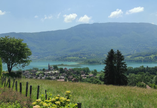 Zicht op dorp, meer en bergen vanaf Family's Camping Le Savoy in Auvergne-Rhône-Alpes, Frankrijk.