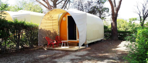 Tenda safari Coco Sweet senza servizi igenici, due sedie rosse davanti e alberi intorno.