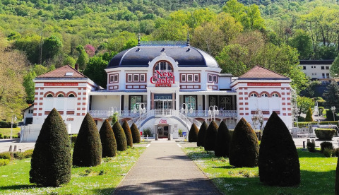 Facade af New Castel Casino omgivet af grønne bakker i nærheden af Challes les Eaux, Auvergne-Rhône-Alpes.