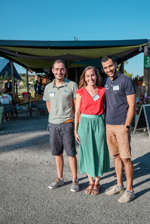 Drie lachende volwassenen staan buiten bij Flower Camping Provence Vallée in Provence-Alpes-Côte d’Azur, Frankrijk.