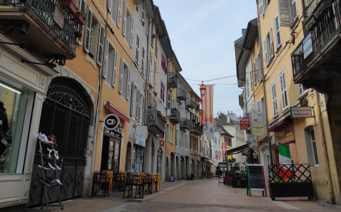 Gezellig, smal straatje met kleurrijke gevels en terrasjes in een Frans dorp, Auvergne-Rhône-Alpes.