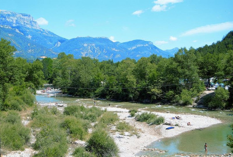 Paysage de rivière, vacanciers et montagnes à Flower Camping la Pinède, Auvergne-Rhône-Alpes, France.