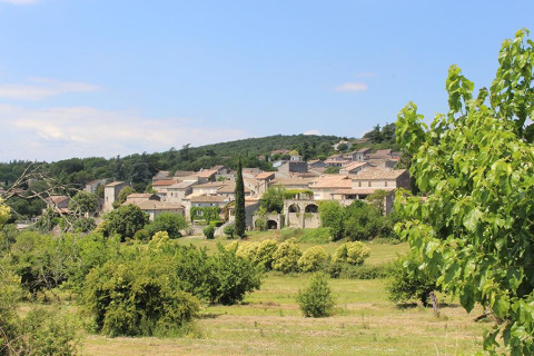 Vue d'un village près du Camping Paradis Family des Issoux en Auvergne-Rhône-Alpes, France entouré de verdure.