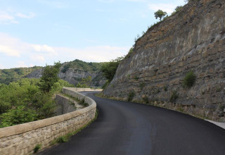 Foto einer kurvenreichen Straße an einer Felswand bei Camping Paradis Family des Issoux, Auvergne-Rhône-Alpes, Frankreich.