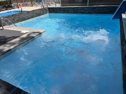 Piscine avec bulles et transats au Flower Camping Provence Vallée, Provence-Alpes-Côte d’Azur, France.
