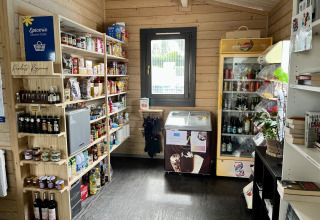 Pequeña tienda de comestibles en Flower Camping Provence Vallée con estantes llenos y nevera.