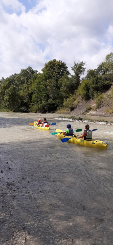 Persone che remano in kayak gialli su un fiume a Flower Camping la Pinède, Auvergne-Rhône-Alpes, Francia.