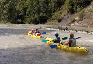 Persone che remano in kayak gialli su un fiume a Flower Camping la Pinède, Auvergne-Rhône-Alpes, Francia.