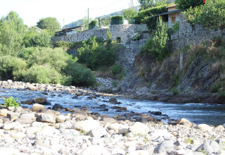 Río con orillas rocosas en Camping Paradis Family des Issoux, Auvergne-Rhône-Alpes, Francia.