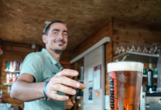 Homme servant une bière au Flower Camping Provence Vallée en Provence-Alpes-Côte d’Azur, France.