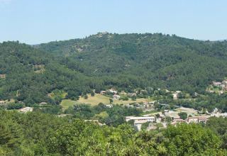 Foto af Camping Paradis Family des Issoux i Auvergne-Rhône-Alpes, Frankrig, omgivet af frodige, grønne bakker.