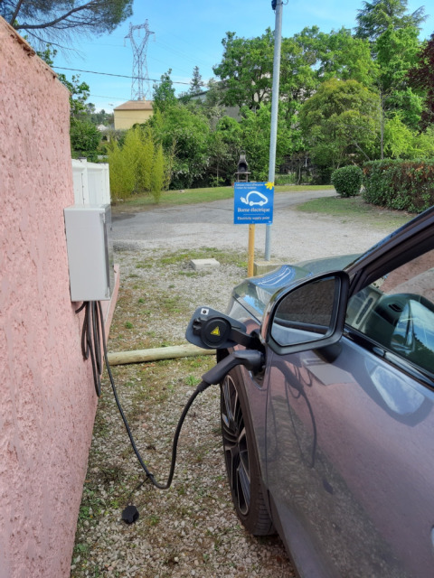 Een elektrische auto laadt op bij een laadstation bij Flower Camping Provence Vallée in Zuid-Frankrijk.