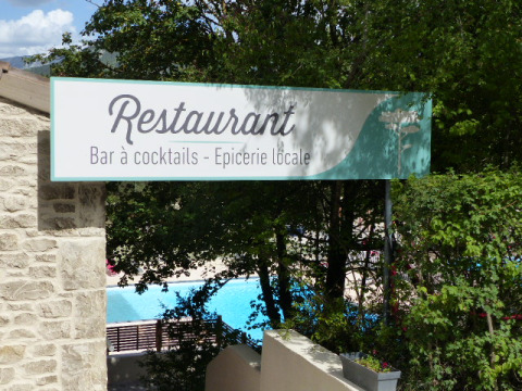 Cartel de restaurante, bar de cócteles y tienda local en Flower Camping la Pinède, Auvernia-Ródano-Alpes, Francia.