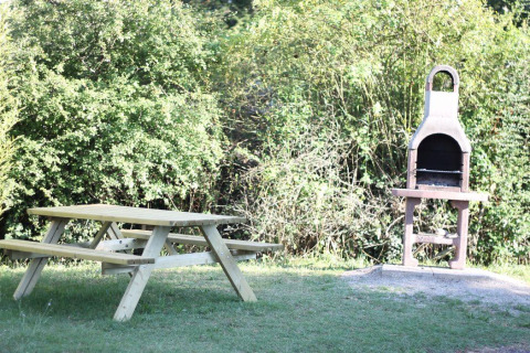 Table de pique-nique et barbecue extérieur au Flower Camping Provence Vallée, Provence-Alpes-Côte d’Azur, France.