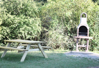 Table de pique-nique et barbecue extérieur au Flower Camping Provence Vallée, Provence-Alpes-Côte d’Azur, France.