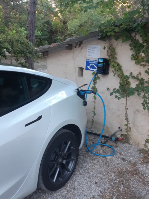 An electric car charging at the Flower Camping la Pinède station in Auvergne-Rhône-Alpes, France.