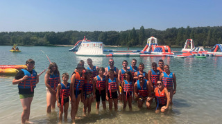 Groep in reddingsvesten bij het opblaasbaar waterpark van Flower Camping Provence Vallée, Frankrijk.