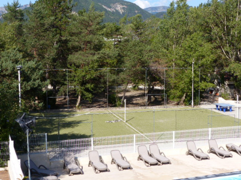 Vue d’un espace sportif avec transats, terrain de football et arbres à Flower Camping la Pinède, France.