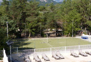 Vista su area sportiva con lettini, campo da calcio e alberi a Flower Camping la Pinède, in Francia.