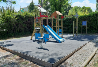 Playground with blue slide and shark rocker at Flower Camping Provence Vallée in Provence, France.