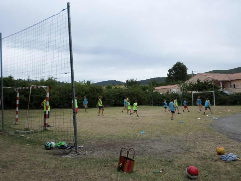Kids play soccer on a grassy field at Flower Camping Provence Vallée in Provence-Alpes-Côte d’Azur, France.