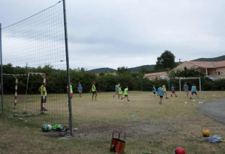 Børn spiller fodbold på en græsmark ved Flower Camping Provence Vallée i Provence-Alpes-Côte d’Azur, Frankrig.