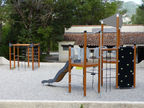 Playground area with climbing frame, slide and equipment at Flower Camping la Pinède holiday park, France.