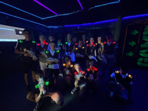 Gruppo di ragazzi che gioca a lasertag in una sala buia a Flower Camping Provence Vallée, Francia.
