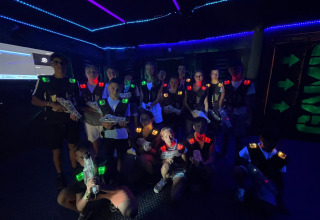 Gruppo di ragazzi che gioca a lasertag in una sala buia a Flower Camping Provence Vallée, Francia.