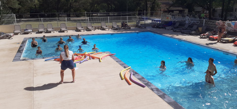 Des vacanciers suivent un cours d’aquagym dans la piscine du Flower Camping la Pinède en Auvergne-Rhône-Alpes.