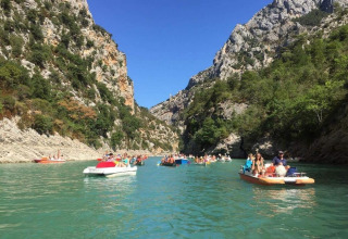 Persone in pedalò navigano su un fiume turchese tra le rocce vicino a Flower Camping Provence Vallée, Francia.