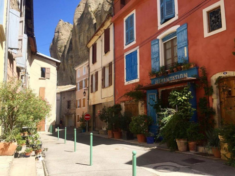 Calle pintoresca con plantas y casas coloridas cerca de Flower Camping Provence Vallée en Provenza, Francia.
