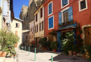 Calle pintoresca con plantas y casas coloridas cerca de Flower Camping Provence Vallée en Provenza, Francia.