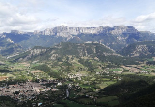 Vista aerea del campeggio Flower Camping la Pinède in Auvergne-Rhône-Alpes, Francia, con montagne sullo sfondo.