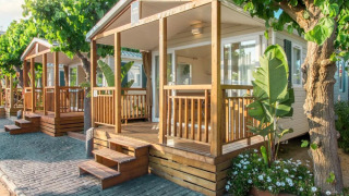 Comfort Mobile Home con due camere da letto, veranda in legno e tanto verde sotto alberi ombrosi.