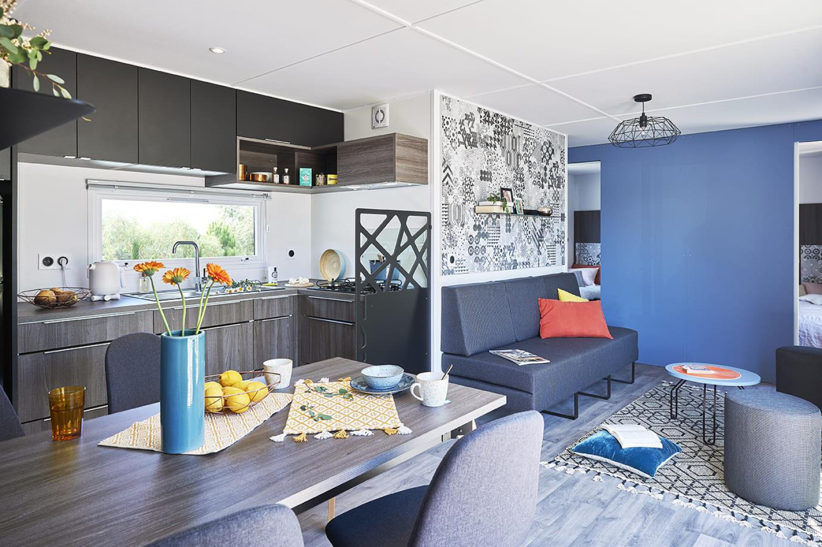 Moderne, gezellige woonkamer en keuken in Paradijs Luxe Stacaravan met stijlvolle en kleurrijke inrichting.