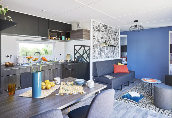 Moderne, gezellige leefruimte en keuken in Paradijs Luxe Stacaravan met een kleurrijk en stijlvol interieur.