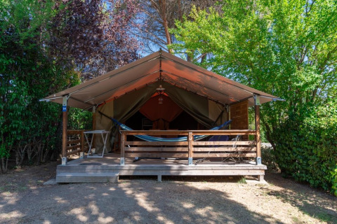 Safari-Zelt namens Freeflower ohne Sanitäranlagen, mit Veranda, Hängematte und von Bäumen umgeben.