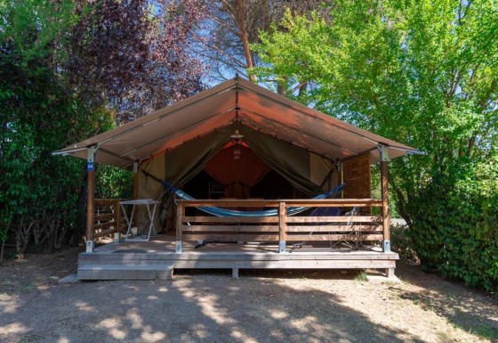 Safari-Zelt namens Freeflower ohne Sanitäranlagen, mit Veranda, Hängematte und von Bäumen umgeben.