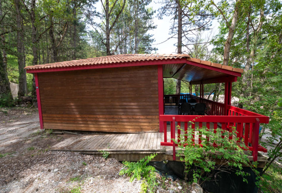 Chalet l'O douce lodge voor mensen met een handicap, houten blokhut in het bos met rode toegankelijke veranda.