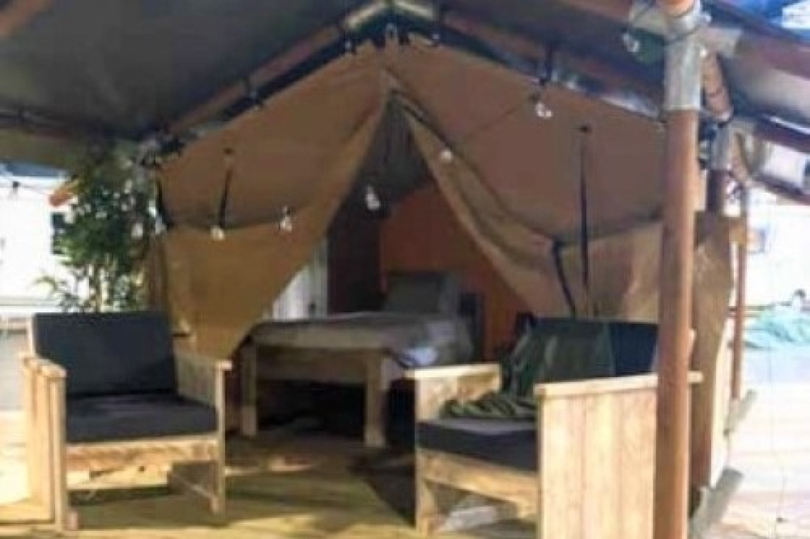 Interieur van de Lodge 'Insolite Bivak' safaritent bij Flower Camping la Pinède met stoelen en bed.