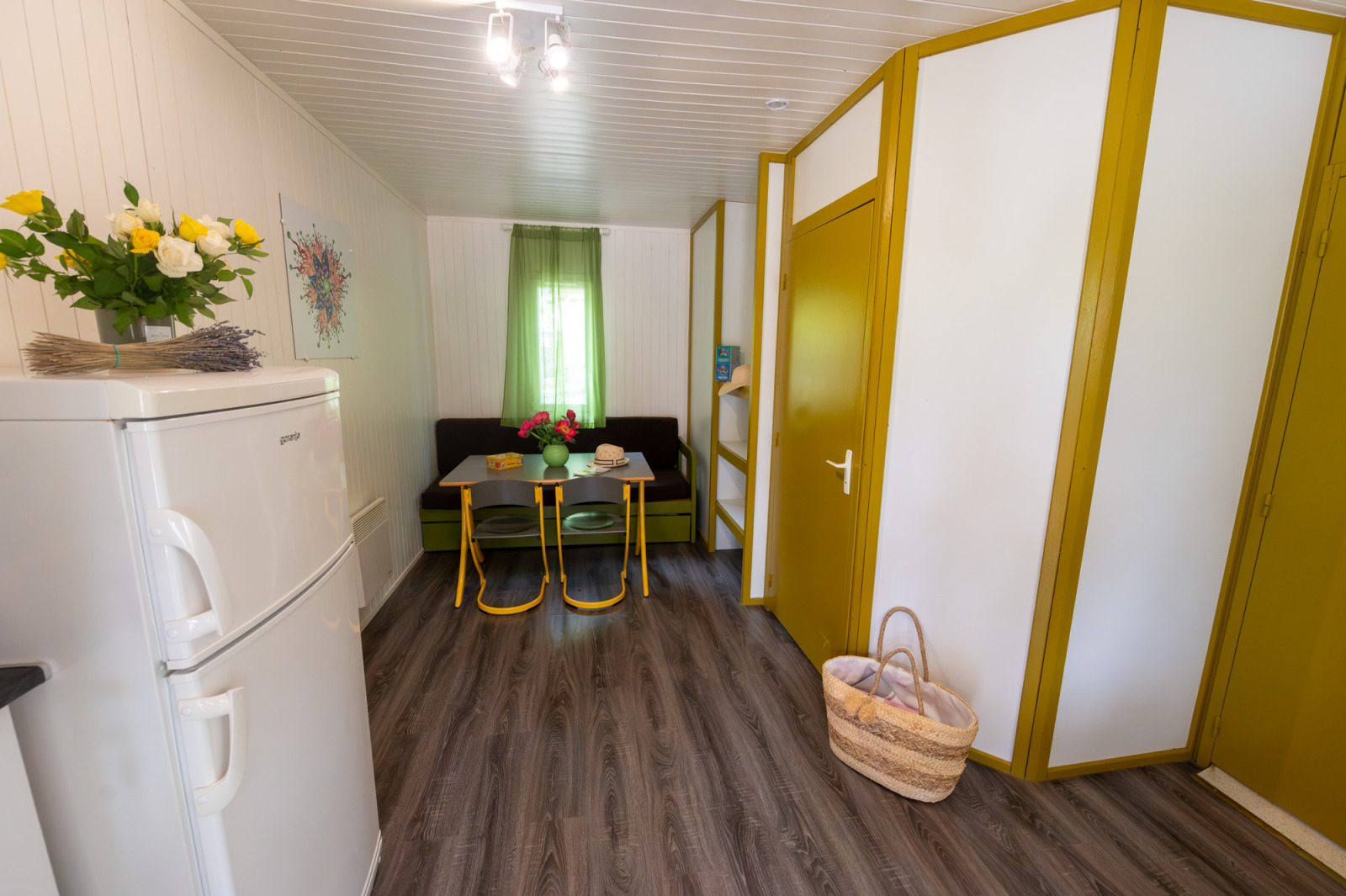 Interieur van Chalet «l'O douce» bij Flower Camping la Pinède in Frankrijk, met eethoek en bloemen.