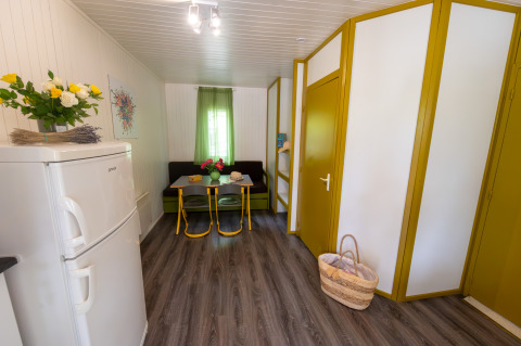Interieur van Chalet «l'O douce» bij Flower Camping la Pinède in Frankrijk, met eethoek en bloemen.