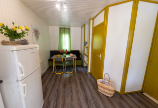 Interieur van Chalet «l'O douce» bij Flower Camping la Pinède in Frankrijk, met eethoek en bloemen.