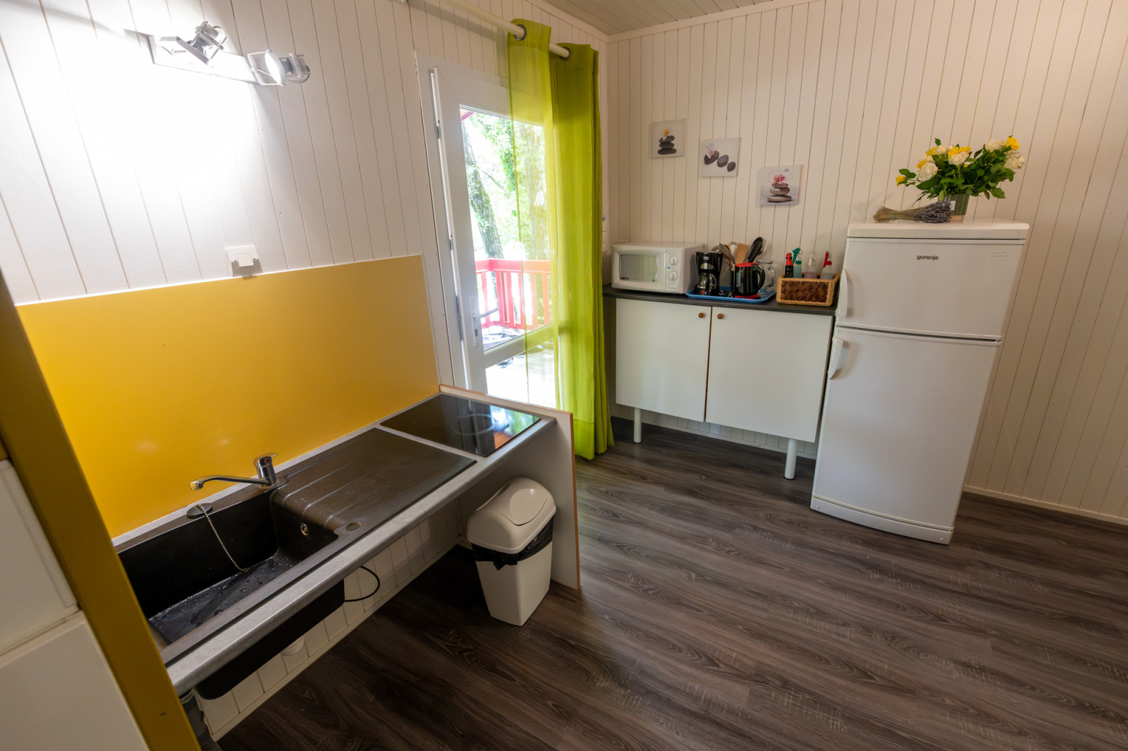 Keuken in Chalet «l'O douce» bij Flower Camping la Pinède in Frankrijk met koelkast, gootsteen en magnetron.
